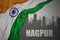 Abstract silhouette of the city with text Nagpur near waving national flag of india on a gray background