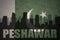 Abstract silhouette of the city with text Peshawar at the vintage pakistan flag