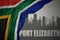 Abstract silhouette of the city with text Port Elizabeth near waving colorful national flag of south africa on a gray background