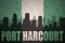 Abstract silhouette of the city with text Port Harcourt at the vintage nigerian flag