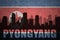 Abstract silhouette of the city with text Pyongyang at the vintage north korea flag