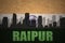 Abstract silhouette of the city with text Raipur at the vintage indian flag