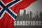 Abstract silhouette of the city with text Sandefjord near waving national flag of norway on a gray background