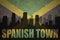 Abstract silhouette of the city with text Spanish Town at the vintage jamaican flag