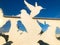 Abstract silhouettes of bird pigeons carved from metal in front of a blue sky