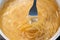 Abstract spaghetti background in boiling broth on fork close up
