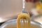 Abstract spaghetti background in boiling broth on fork close up