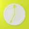 Abstract spoon and fork on white round plate in a form of clock