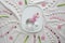 Abstract Springtime background. Pink pearl hyacinth flower in glass on ceramic plate. Flat lay with hearts, candy