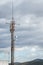 Abstract telecommunication tower antenna at bright sky background and mountains