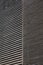An abstract texture. a fragment of the facade of a modern architecture building. oblique diagonal gray-brown 3D lines.