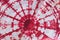 Abstract tie dyed fabric of red color on white cotton
