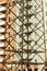 Abstract vertical industrial background of brick multistory building under construction behind close up power lines pylon tower