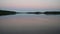 Abstract view of the closeup dandelion beside the lake during sunset through the horizon.