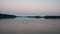 Abstract view of the closeup dandelion beside the lake during sunset through the horizon.