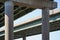 Abstract view of elevated interstate highway from below. Concrete pillars with green steel beam infrastructure