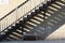 Abstract view of a vintage city fire escape stairs casting unique shadows in late day sun