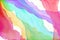 Abstract watercolor background in rainbow colors of blue red yellow green purple and pink in layers of streaming flowing ribbons o