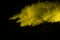 Abstract of yellow powder explosion on black background. Yellow powder splatted isolate. Colored cloud. Colored dust explode. Pain