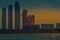 Abu Dhabi city skyline along Corniche beach taken from a boa showing Etihad tower and Emirates palace under sunset