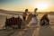 ABUDHABI/UAE - 13DEZ2018 - Camels in the desert of Abu Dhabi with their trainer and woman tourist. UAE