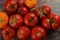 Abundance ripe organic tomatoes on dark rustic background. Colorful tomatoes