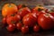 Abundance ripe organic tomatoes on dark rustic background. Colorful tomatoes