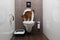 Abyssinian Cat Sits on toilet Bowl and Curious Looking