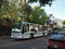 AC Transit bus with ads displayed on side driving down the street