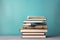 Academic essentials, Stack of books on wooden table, pastel blue background