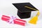 Academic graduation cap student and a scroll diploma. Red document of the graduate student, certificate of graduation from the