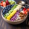 Acai bowl with strawberries, banana, blueberries, kiwi fruit, nuts and granola on wooden table. Nourishing breakfast full of