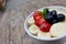 acai bowls with fresh fruit strawberry, blueberry, banana in white bowl on wooden table.