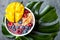 Acai breakfast superfoods smoothie bowl with mango, blueberry, cherry, coconut flakes. Overhead, top view