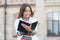 Access to much more than just book. Knowledge concept. Little girl hold book. Girl with book school building background