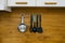 Accessories for cooking hang on a metal holder in the kitchen: spatula, colander, whisk