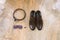 Accessories for the groom: brown shoes with laces, cufflinks, belt and purple bow tie on a beige background