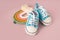 Accessories toys and small sneakers for newborns on a pastel background with an empty space for text. Cute concept of childhood an