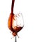 Accidental spill, stop action capture of red wine splashing on elegant glass isolated on white