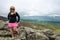 Accomplished smiling woman hiker poses at the summit of LIttle Stony Man, a hike in Shenandoah National Park in Virginia on a