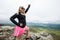 Accomplished smiling woman hiker poses at the summit of LIttle Stony Man, a hike in Shenandoah National Park in Virginia on a