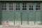Accordian fold green painted weathered garage doors with windows, creative copy space