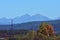 Accumulation dam in autumn season with high mountains on the horizon