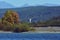 Accumulation dam in autumn season with high mountains on the horizon