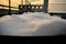 Accumulation of snow on the table outside with blurred chimneys