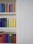 Accurate bookcase with colorful covers in white wall