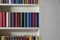 Accurate bookshelf with colorful book covers in a white wall