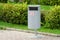 Accurate cylindrical metal rubbish bin on background of a well-kept lawn