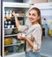 Accurate and positive girl standing near fridge