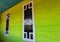 Aceh,Indonesia - April 18th 2021 : The white, black-glazed windows installed in the green wooden house are very beautiful